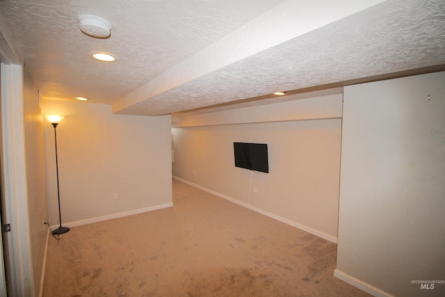 finished below grade area featuring recessed lighting, carpet flooring, a textured ceiling, and baseboards