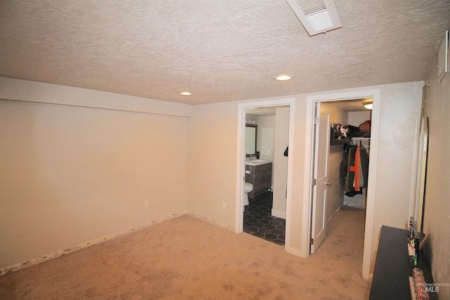 interior space with a closet, visible vents, a spacious closet, and a textured ceiling