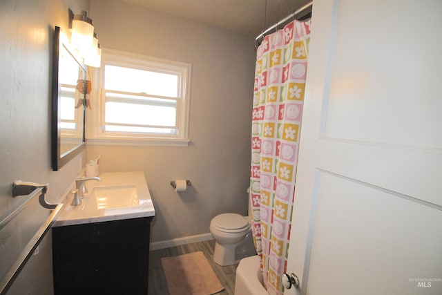 bathroom with curtained shower, toilet, wood finished floors, vanity, and baseboards