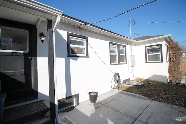 view of side of home with entry steps, a patio area, and stucco siding