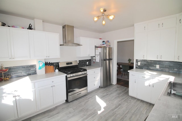 kitchen with decorative backsplash, range hood, stainless steel appliances, light countertops, and white cabinetry