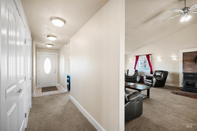 hall with baseboards, lofted ceiling, and carpet floors