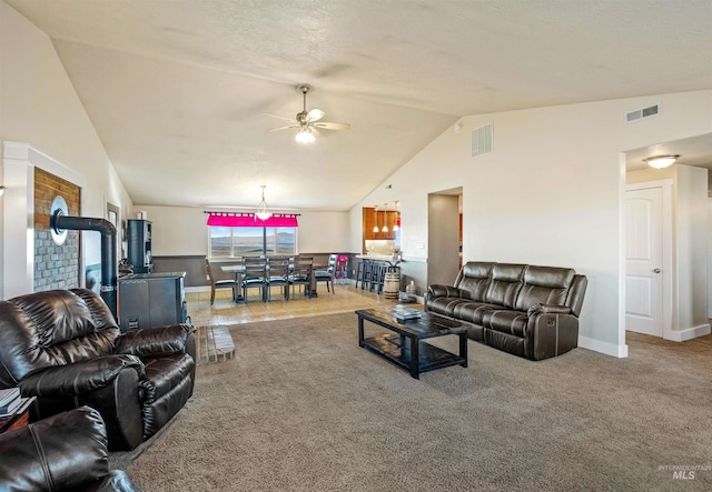 carpeted living room featuring lofted ceiling, baseboards, visible vents, and ceiling fan