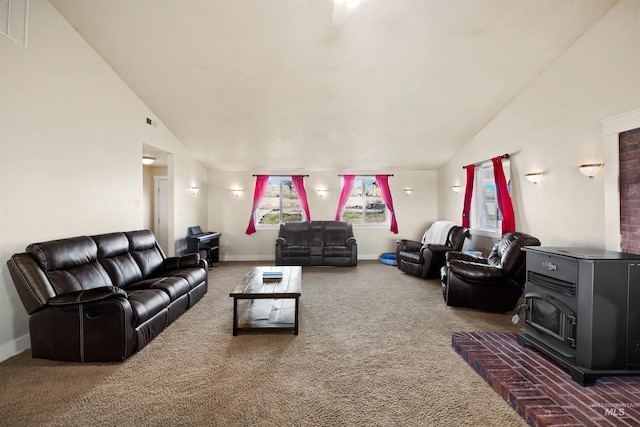 carpeted living room featuring visible vents, baseboards, high vaulted ceiling, and a wood stove