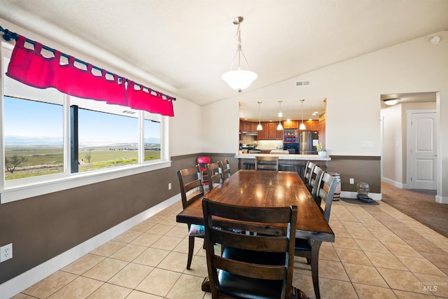 dining space featuring light tile patterned flooring, visible vents, baseboards, and lofted ceiling