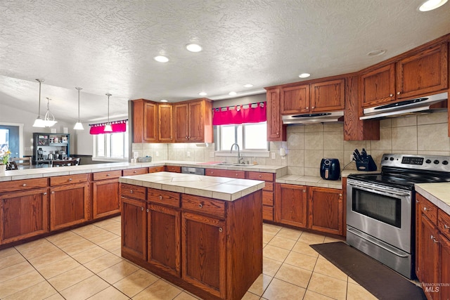 kitchen with under cabinet range hood, light tile patterned flooring, stainless steel appliances, and a sink