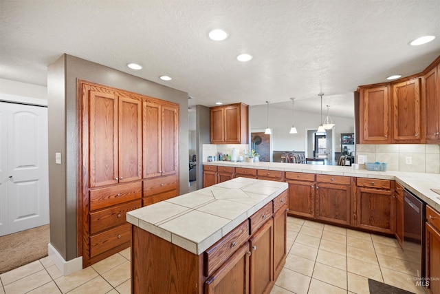 kitchen featuring brown cabinets, tasteful backsplash, and dishwasher