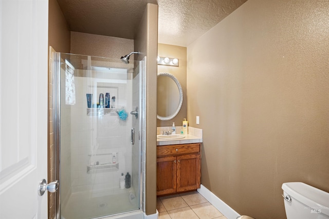 bathroom featuring tile patterned floors, vanity, a shower stall, and toilet