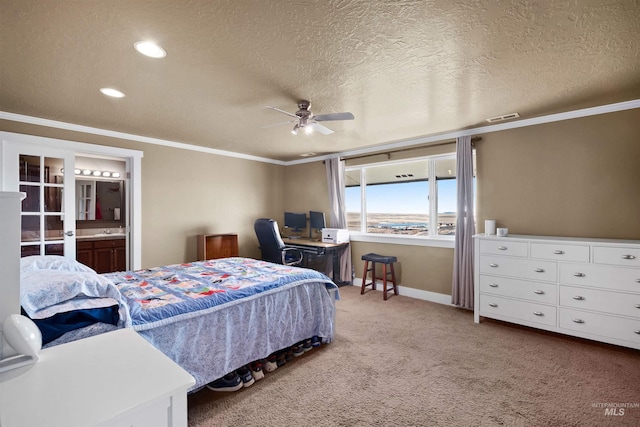 carpeted bedroom featuring baseboards, visible vents, ornamental molding, ensuite bathroom, and a textured ceiling