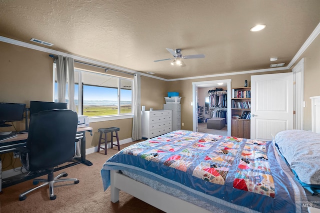 bedroom with crown molding, carpet flooring, visible vents, and a textured ceiling