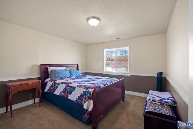 bedroom with carpet flooring, visible vents, baseboards, and a textured ceiling