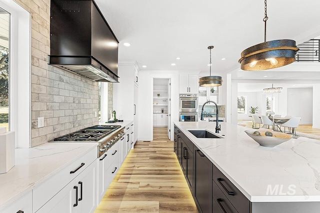 1458 W Sandy Ct, Meridian, ID 83646 - kitchen with a sink, wall chimney range hood, stainless steel appliances, plenty of natural light, and recessed lighting