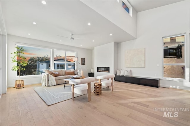 living room with ceiling fan and light hardwood / wood-style flooring