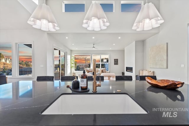 kitchen featuring hanging light fixtures, ceiling fan, and sink