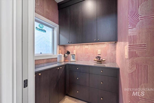 kitchen featuring dark brown cabinets and backsplash