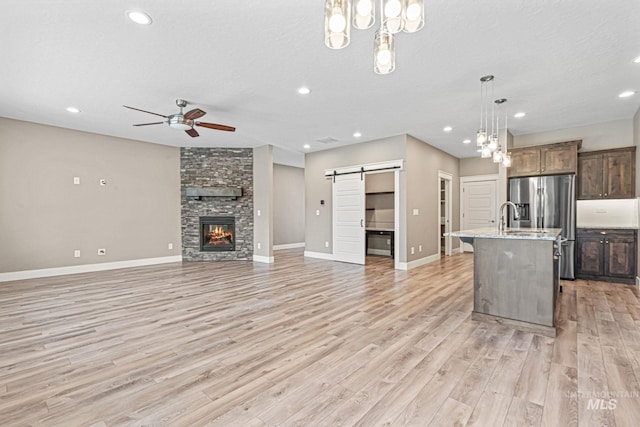 1073 W Smoky Quartz St, Kuna, ID 83634 - kitchen featuring a barn door, a ceiling fan, light wood-style flooring, recessed lighting, and open floor plan