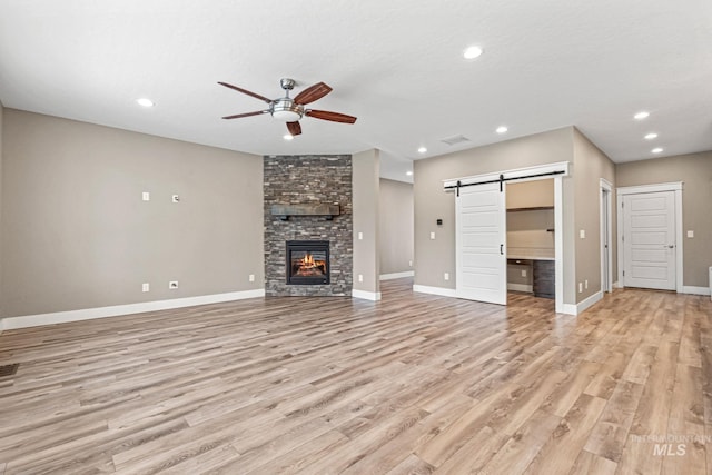 1073 W Smoky Quartz St, Kuna, ID 83634 - unfurnished living room featuring ceiling fan, light wood-style flooring, baseboards, a barn door, and recessed lighting