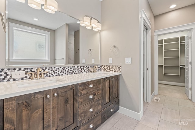 1073 W Smoky Quartz St, Kuna, ID 83634 - full bath with backsplash, tile patterned floors, a walk in closet, baseboards, and double vanity