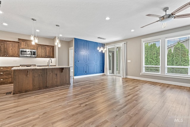 1073 W Smoky Quartz St, Kuna, ID 83634 - kitchen featuring appliances with stainless steel finishes, baseboards, light wood-style flooring, recessed lighting, and open floor plan
