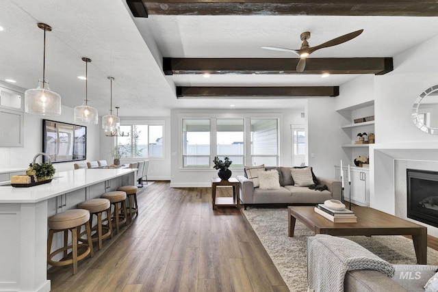 6251 S Utmost Ln, Meridian, ID 83642 - living room featuring dark wood-type flooring, a ceiling fan, recessed lighting, a glass covered fireplace, and beam ceiling