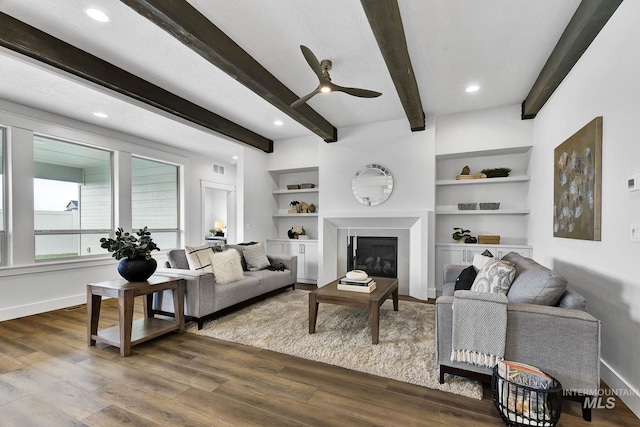 6251 S Utmost Ln, Meridian, ID 83642 - living room featuring dark wood finished floors, ceiling fan, beamed ceiling, a glass covered fireplace, and recessed lighting