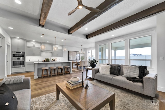 6251 S Utmost Ln, Meridian, ID 83642 - living room with beamed ceiling, light wood-style floors, a chandelier, a ceiling fan, and recessed lighting
