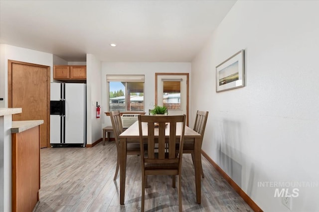 dining room with baseboards and light wood finished floors