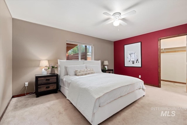 bedroom featuring baseboards, a ceiling fan, a closet, and light colored carpet