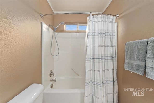 full bathroom featuring a textured wall, toilet, and shower / bath combination with curtain