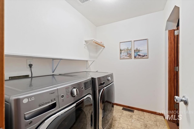laundry area with stone finish floor, laundry area, visible vents, baseboards, and washer and clothes dryer