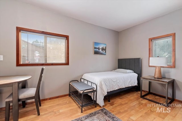 bedroom featuring baseboards and light wood finished floors