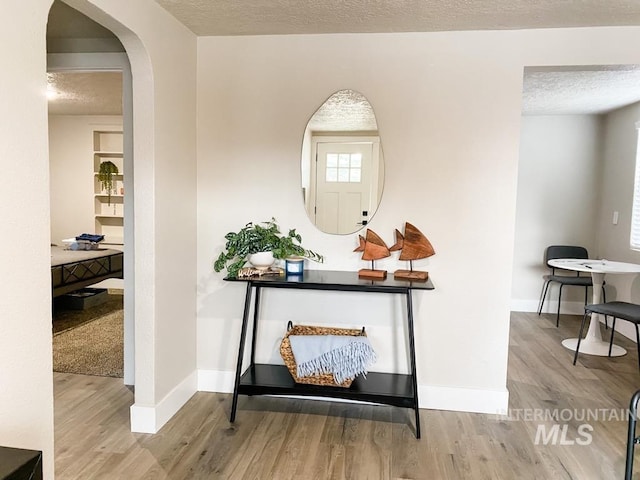 1101 Clithero Dr, Boise, ID 83703 - hallway featuring a textured ceiling, baseboards, and wood finished floors