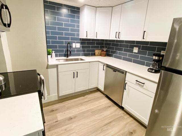 1101 Clithero Dr, Boise, ID 83703 - kitchen with light wood-type flooring, light countertops, white cabinets, stainless steel appliances, and a sink