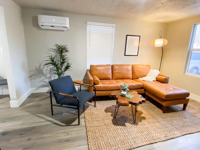 1101 Clithero Dr, Boise, ID 83703 - living area with light wood-style flooring, an AC wall unit, baseboards, and a textured ceiling