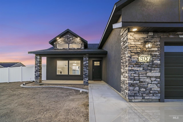 507 Jesse Ave, Twin Falls, ID 83301 - exterior entry at dusk with stone siding and stucco siding