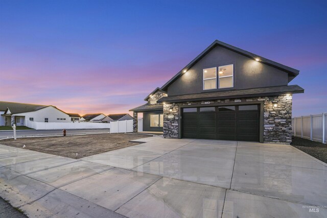 507 Jesse Ave, Twin Falls, ID 83301 - view of front of home with stone siding, driveway, an attached garage, and stucco siding