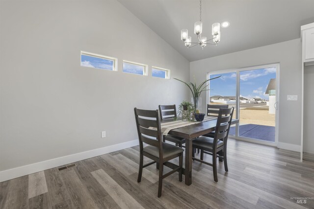 507 Jesse Ave, Twin Falls, ID 83301 - dining space featuring a chandelier, high vaulted ceiling, dark wood-style floors, and baseboards