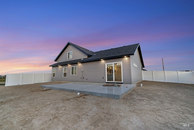 507 Jesse Ave, Twin Falls, ID 83301 - back of property at dusk featuring a patio, a fenced backyard, and a shingled roof