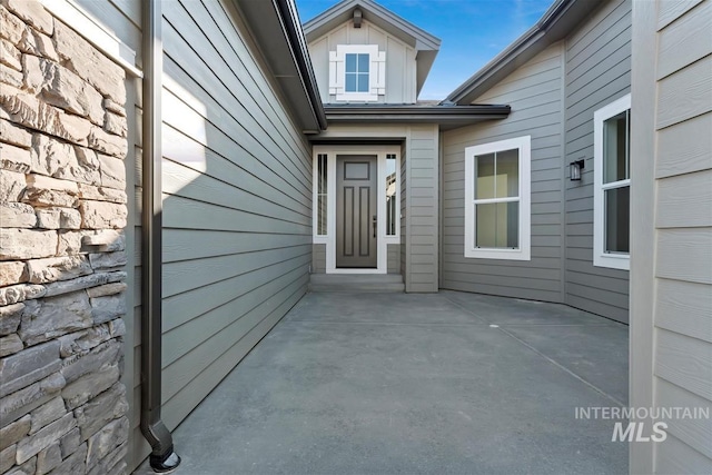 view of exterior entry with a patio area