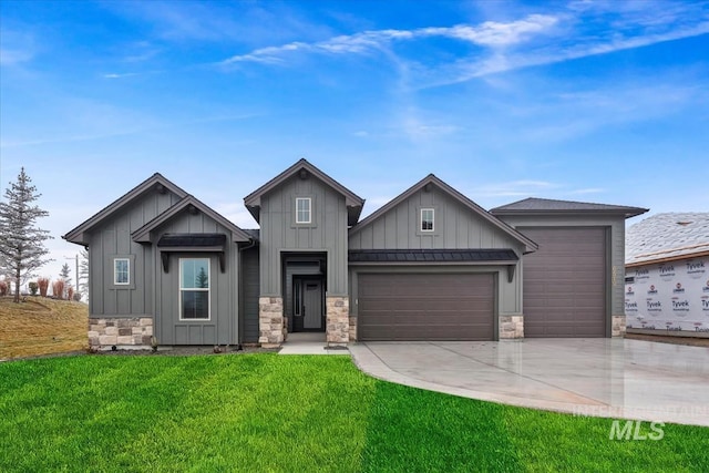 view of front of property featuring board and batten siding, a front yard, stone siding, and an attached garage