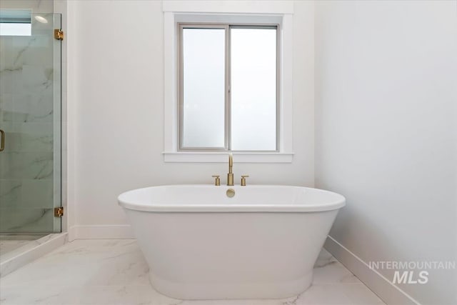 full bath with marble finish floor, a shower stall, and baseboards