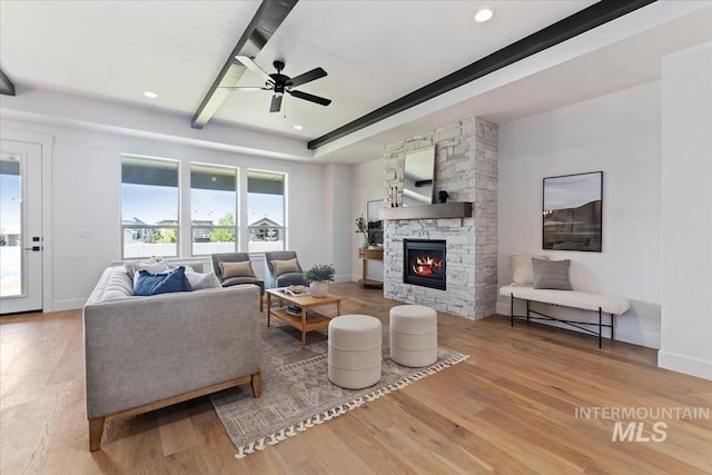 living room featuring ceiling fan, a fireplace, and wood-type flooring