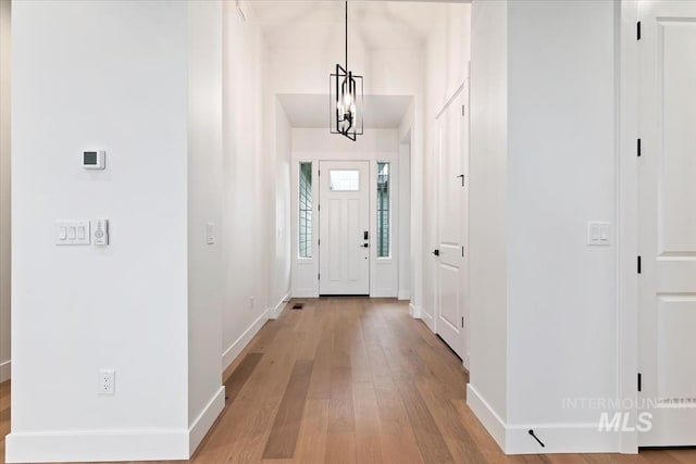 foyer entrance featuring baseboards and light wood-style floors