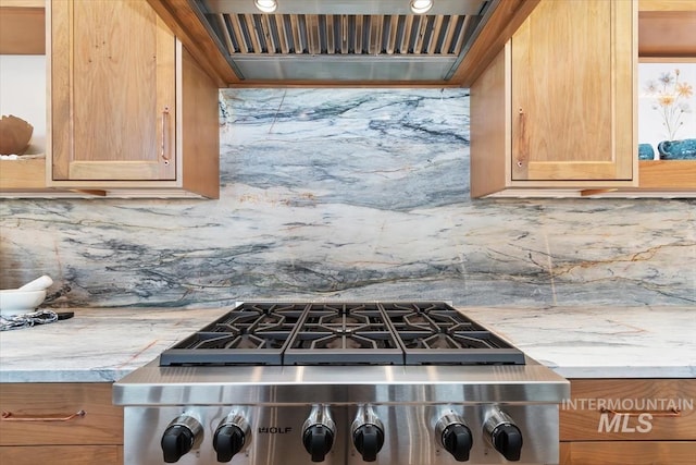 kitchen featuring premium range hood, tasteful backsplash, light stone countertops, and stove