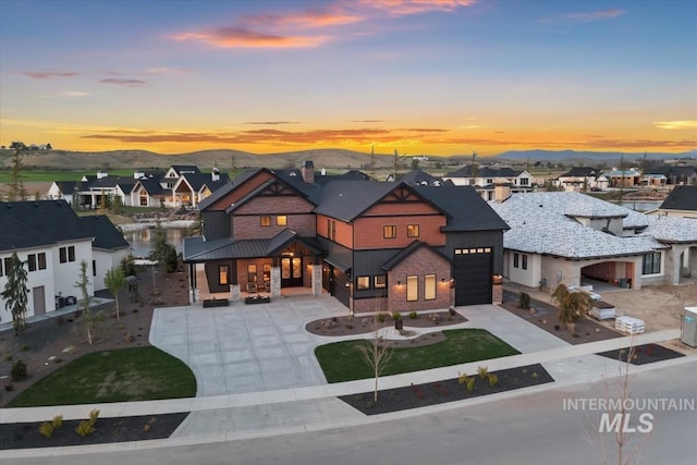 view of front of property featuring driveway, brick siding, a residential view, and a garage