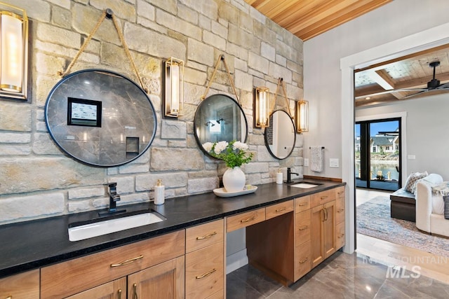 bathroom with double vanity, ensuite bath, wood ceiling, and a sink