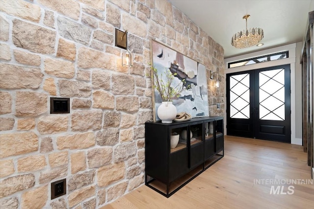 foyer entrance featuring wood finished floors and french doors