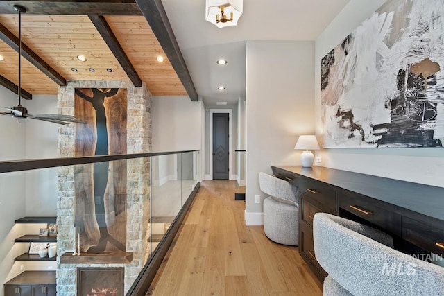 hallway featuring light wood-style floors, beamed ceiling, wooden ceiling, baseboards, and recessed lighting