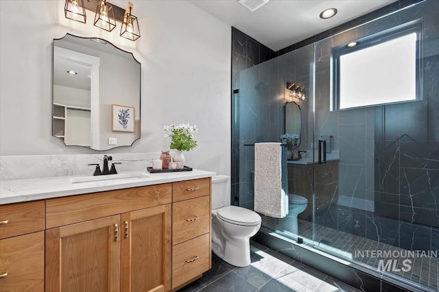 full bath with toilet, vanity, a marble finish shower, and tile patterned floors