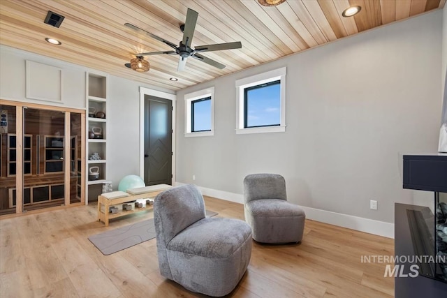 sitting room with wood ceiling, ceiling fan, baseboards, and light wood finished floors